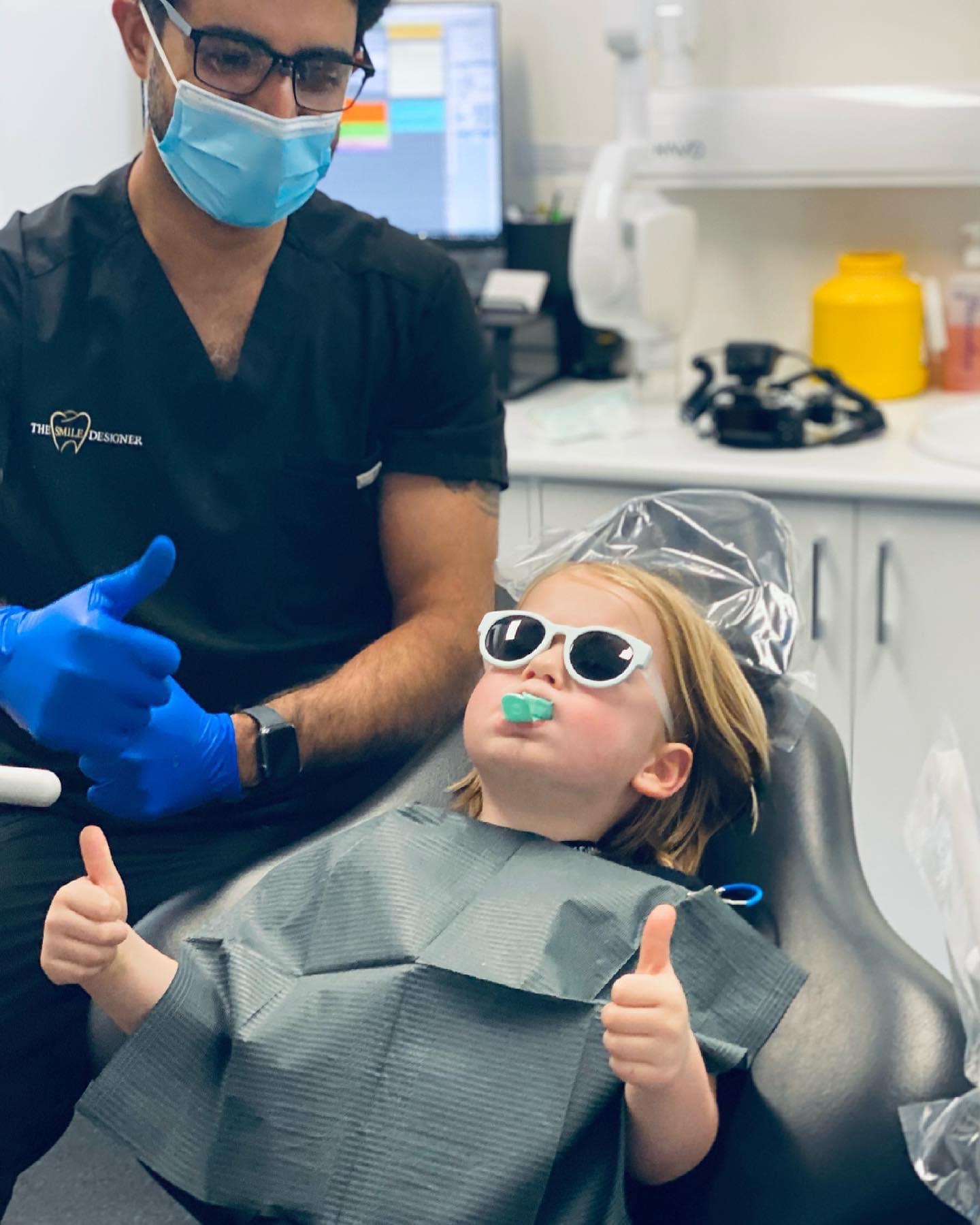 A happy young patient giving a thumbs up at The Smile Designer — kids dentist Melbourne