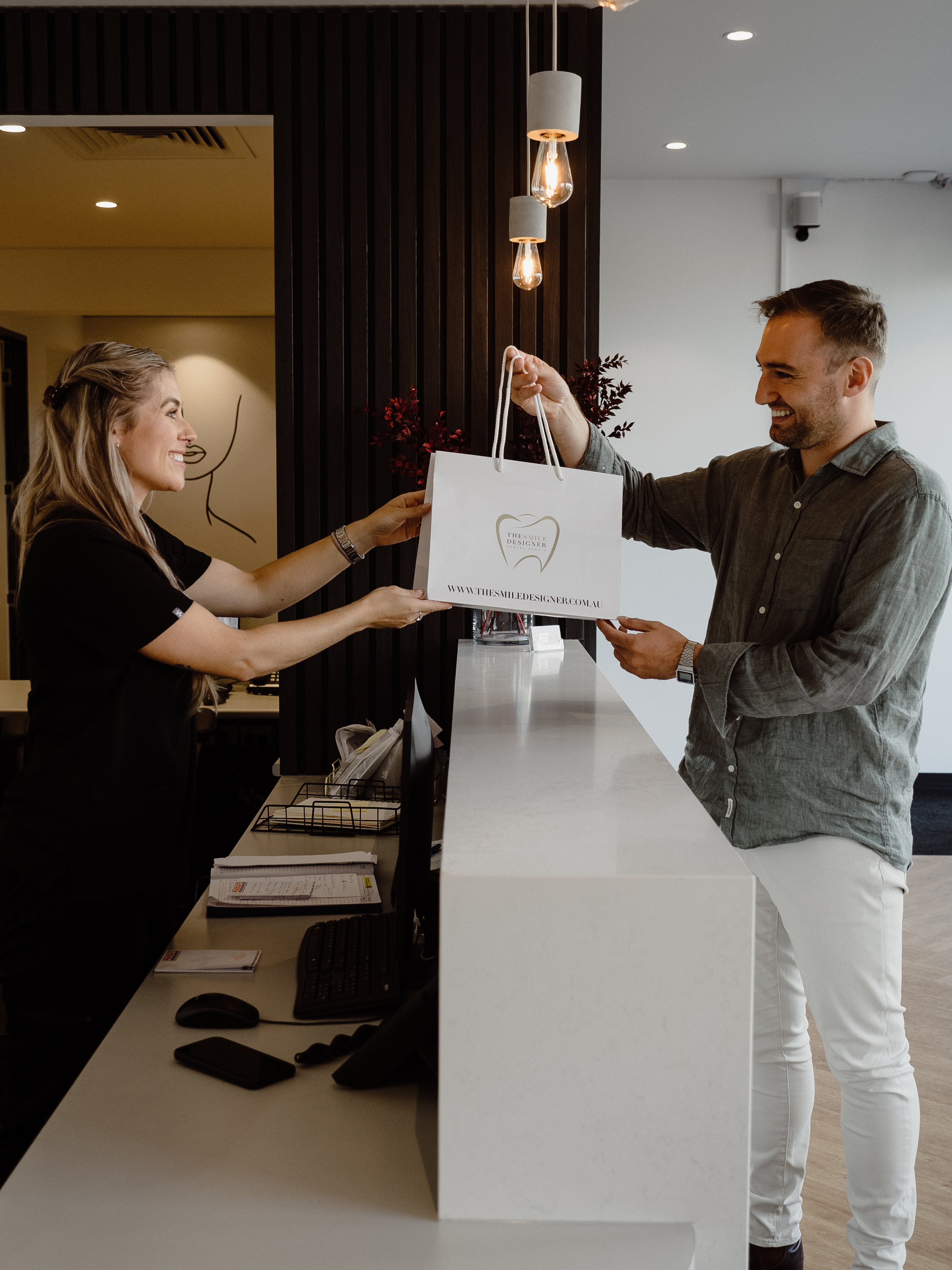 A patient collecting their gift bag at The Smile Designer reception — cosmetic dentistry Melbourne